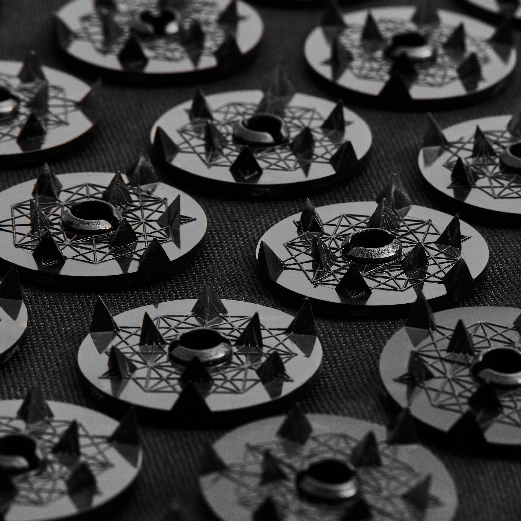 Close-up of Level 4 Shakti spikes with geometric designs on a textured surface