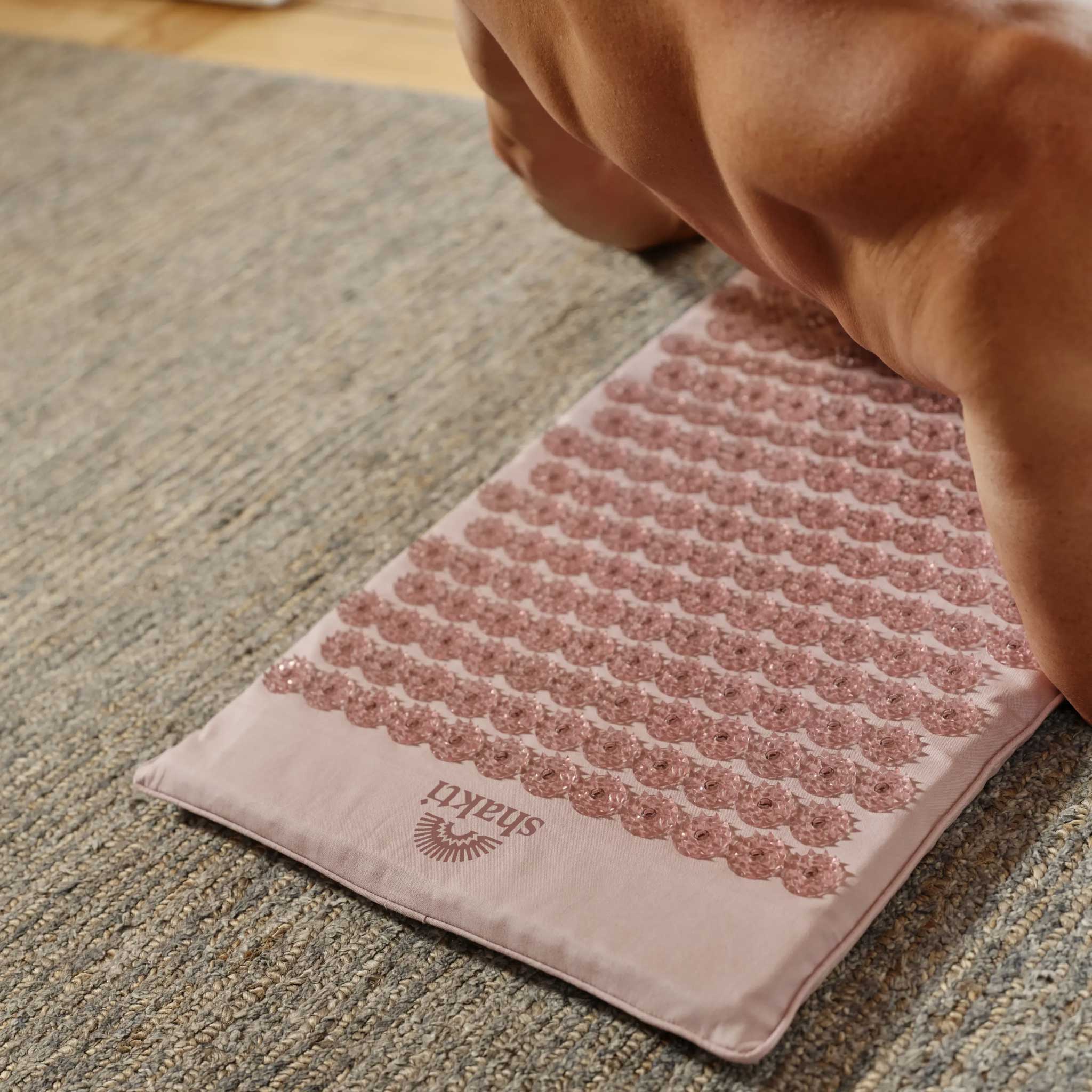 02_Shakti_Premium_Acupressure_Mat_Lifestyle_Rolling_Back_Pale_Petal_L2.jpg